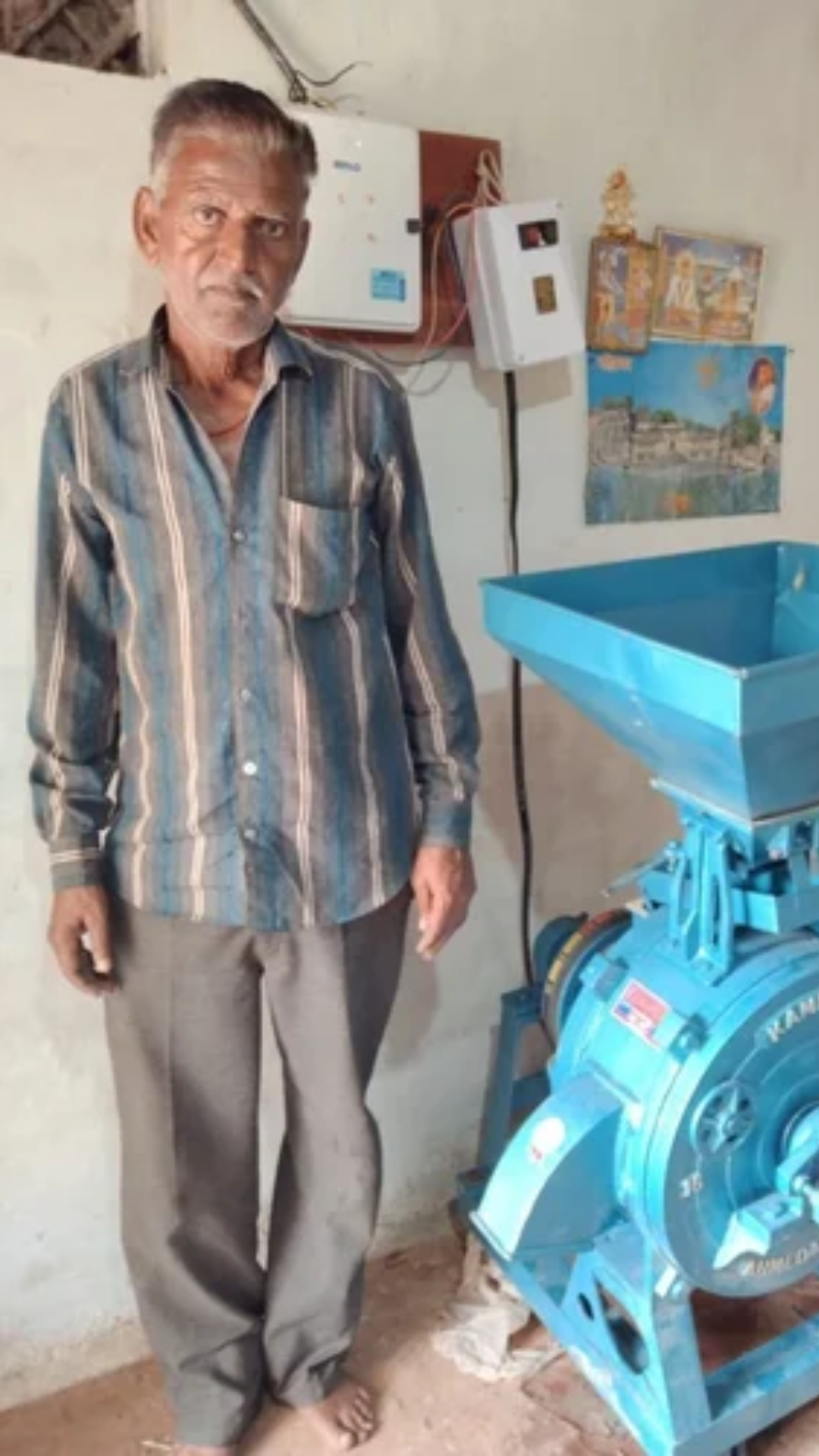 A old man using a Atta Chakki